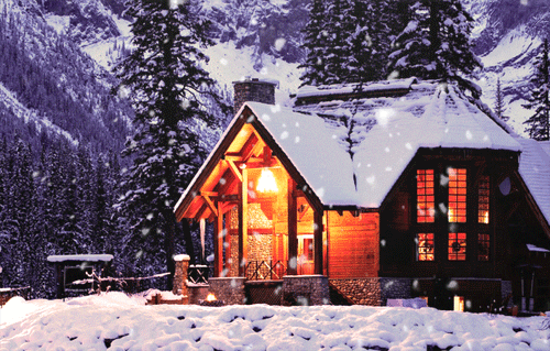 a cabin is lit up in the snow
